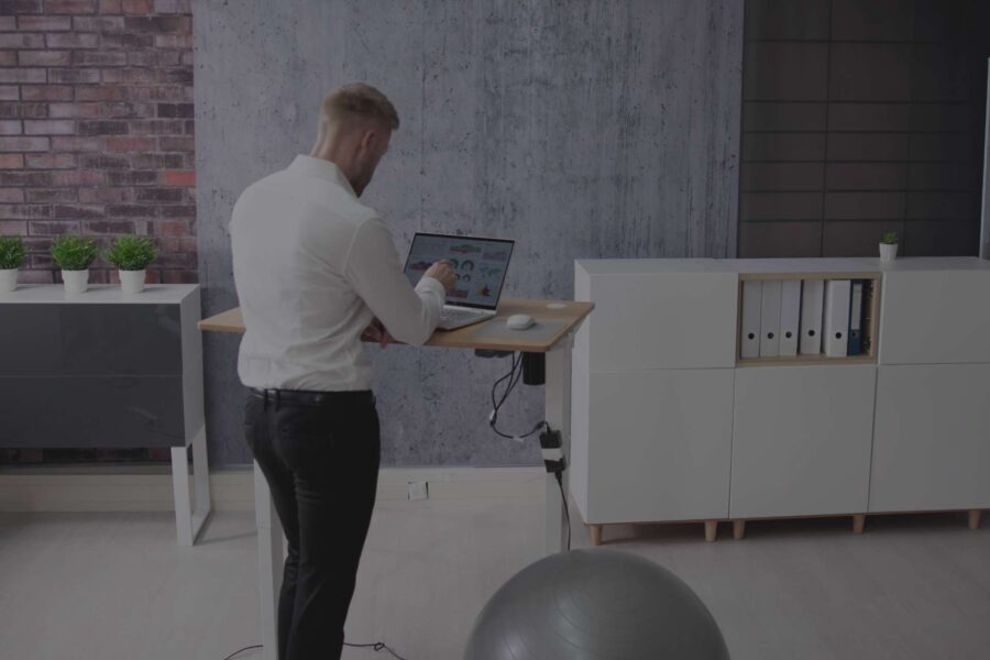 back-view-adult-male-working-from-home-with-sit-stand-desk